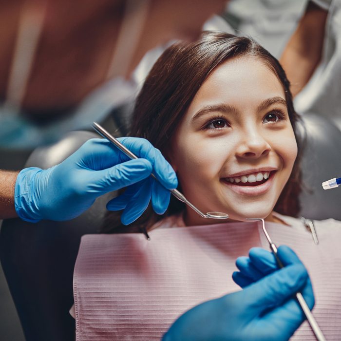 Cute girl in dental clinic. Child in stomatological cabinet with dentists.